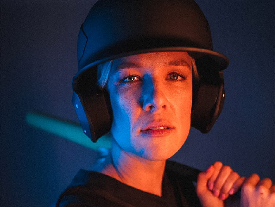 softball-player-headshot-posing-with-helmet-and-bat
