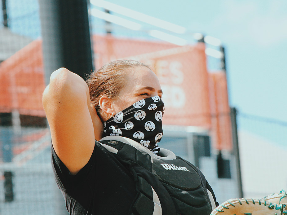 Gwen Svekis stands at home plate wearing an Athletes Unlimited mask.