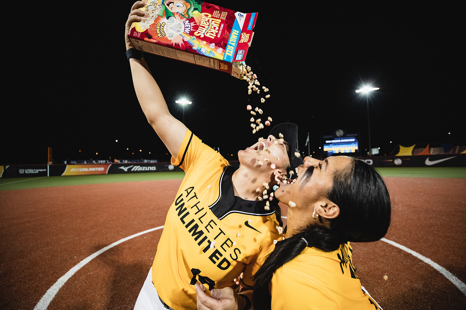 Dejah Mulipola and Hannah Flippen celebrate a home run with Lucky Charms.