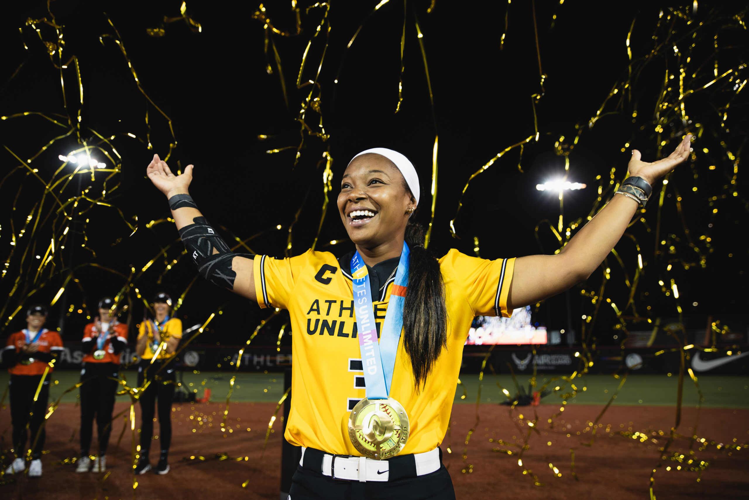 Odicci Alexander celebrates her championship surrounded by gold confetti.