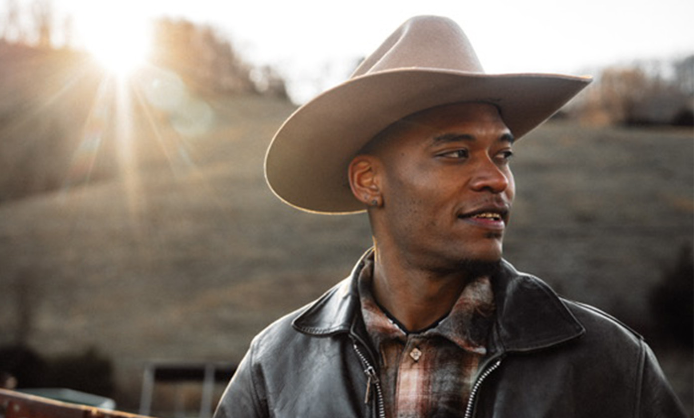 2’Live Bre in a cowboy hat looking off to the side